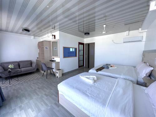 a bedroom with a large bed and a couch at Galaxy Sunrise Sea View in Fulidhoo
