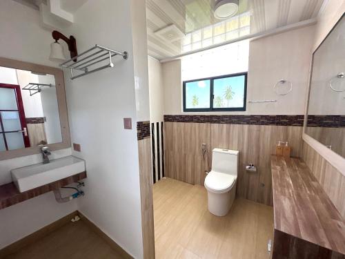 a bathroom with a toilet and a sink and a window at Galaxy Sunrise Sea View in Fulidhoo