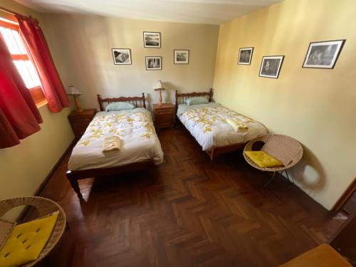 a room with two beds and a table and chairs at La Casa de Zarela in Huaraz
