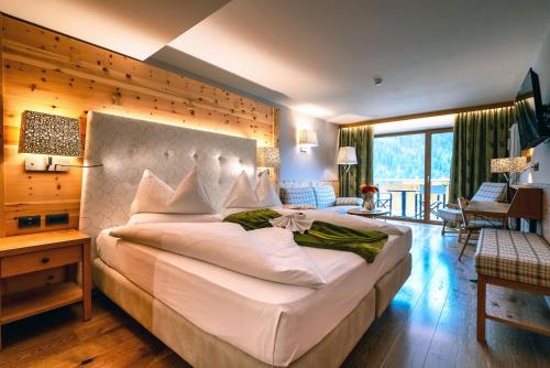 a bedroom with a large white bed in a room at Hotel Cesa Tyrol in Canazei