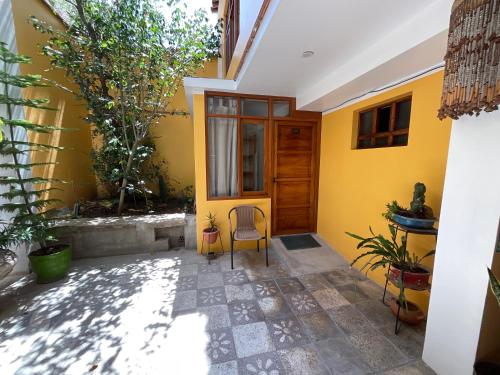 a yellow house with two chairs in a courtyard at La Casa de Zarela in Huaraz