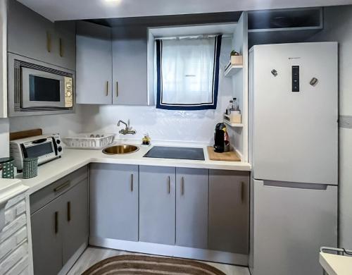 a kitchen with white cabinets and a white refrigerator at The new Gurami Beach House in Rincón de la Victoria