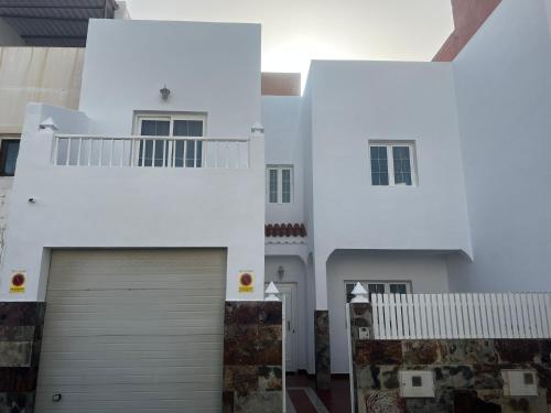 uma casa branca com garagem em Casa Islas 1 em Ingenio