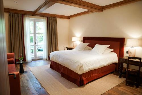 a bedroom with a large bed and a large window at Hostellerie De Levernois in Levernois