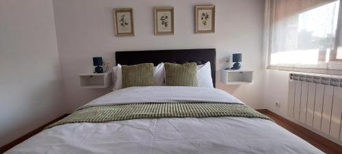 a bedroom with a large bed with two windows at Casa Xoubiña in Mos