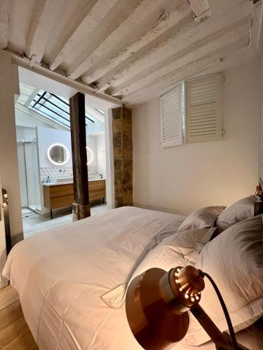 - une chambre avec un grand lit et une lampe dans l'établissement La Suite de Montorgueil, à Paris