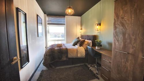1 dormitorio con cama, escritorio y ventana en The Beaumonts en Darlington