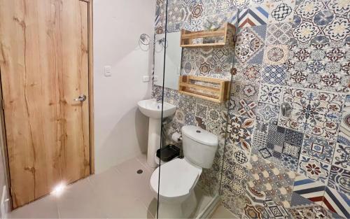 a bathroom with a toilet and a sink at Hostal Las Guaduas in Santa Marta