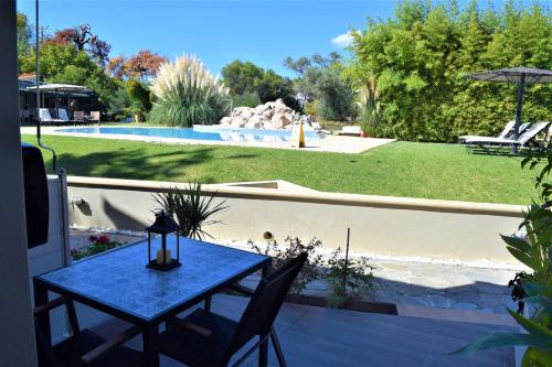 a blue table and chairs on a patio with a pool at Simatos αpARTments & Studios in Lassi