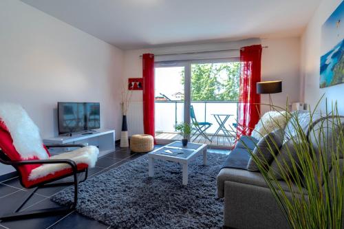 un salon avec un canapé et une télévision dans l'établissement Le Coquelicot 3 étoiles - Proche vieille ville, calme & confort, à Annecy