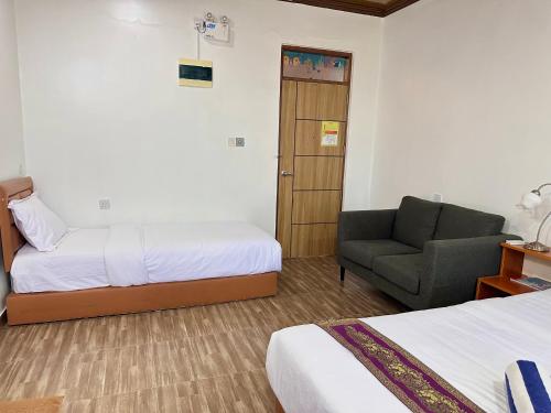a hotel room with a bed and a chair at Galaxy Sunrise Sea View in Fulidhoo