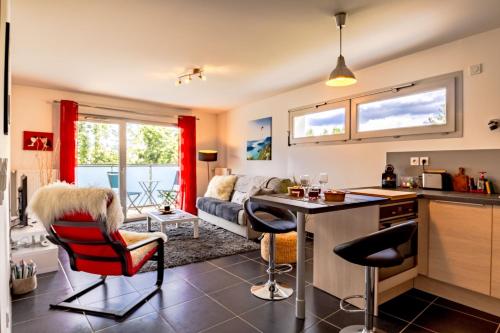 Una cocina y una sala de estar con mesa y sillas. en Le Coquelicot 3 étoiles - Proche vieille ville, calme & confort, en Annecy