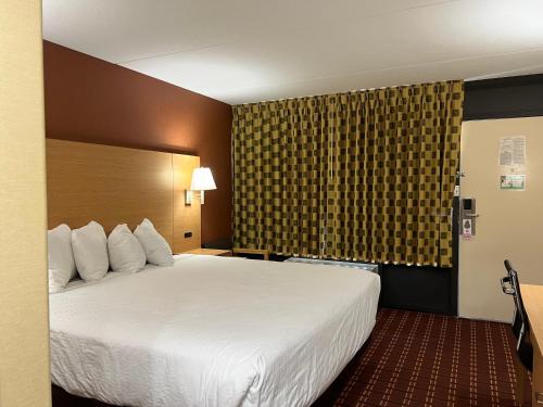 una habitación de hotel con una gran cama blanca y una ventana en Serenity Inn Sweetwater, en Sweetwater