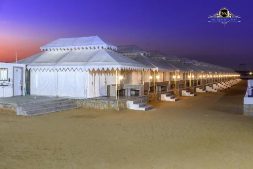 a row of white tents on the beach at night at NK Desert Camp Jaisalmer in Sām