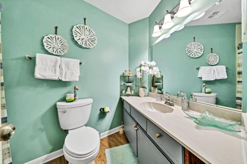 a bathroom with a sink and a toilet and a mirror at Crystal Village II 6B - Close to the Beach 2BD 2BA in Destin