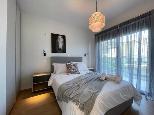 a bedroom with a bed and a large window at Urban Oasis in Ellinikon in Athens