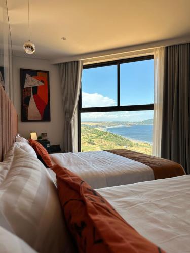 2 camas en una habitación de hotel con ventana grande en S0410 Apec Mui Ne en Ấp Thiẹn Ái