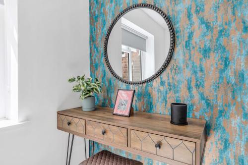 a dressing table with a mirror on a wall at We Stay Baxter Gate in Loughborough