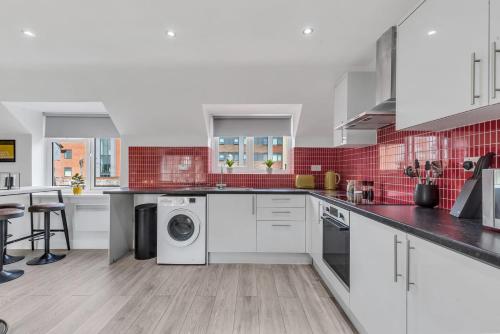 a large kitchen with white appliances and red tiles at We Stay Baxter Gate in Loughborough