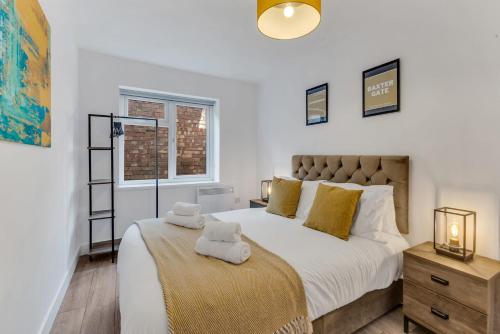 a bedroom with a large bed with two towels on it at We Stay Baxter Gate in Loughborough