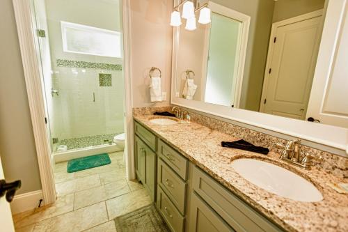 baño con 2 lavabos y espejo grande en Wanderlust - Modern Home Close to the Beach Private Pool en Destin