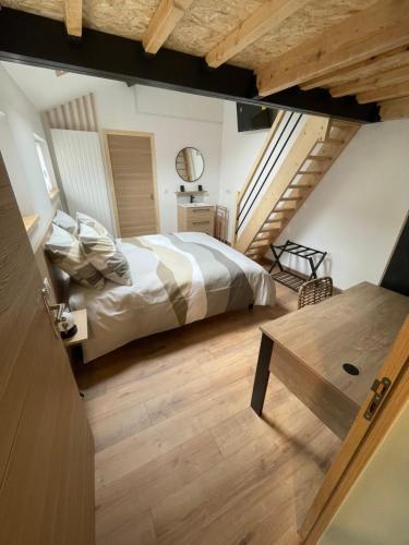um quarto com uma cama e piso em madeira em Au Bord de L'Eau em Écluzelles