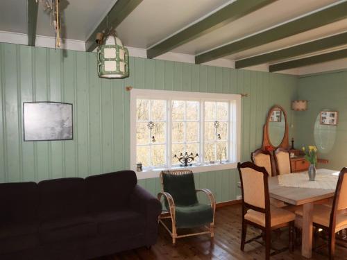d'un salon avec une table, des chaises et une fenêtre. dans l'établissement Holiday Home Sjøhytta - FJH675 by Interhome, à Bekkjarvik