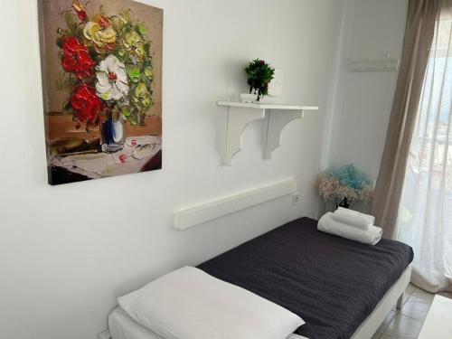 a room with a bed and a painting on the wall at Room to rent in Mýkonos City