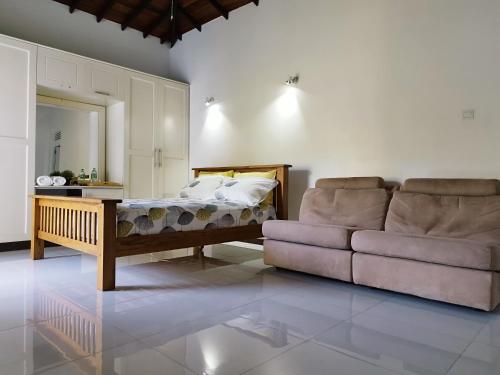 a living room with a couch and a bed at Boztreve Home in Kandy