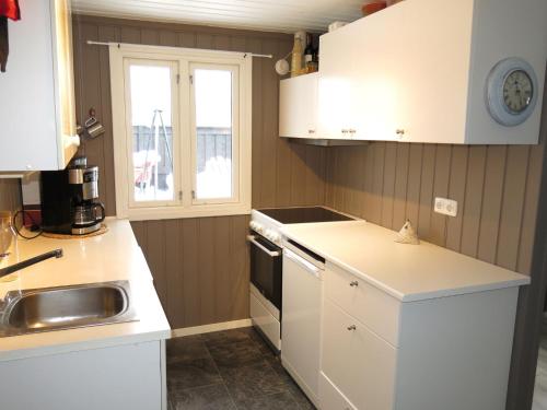 una cocina con armarios blancos y fregadero en Chalet Solbu - SOW087 by Interhome, en Fossdal