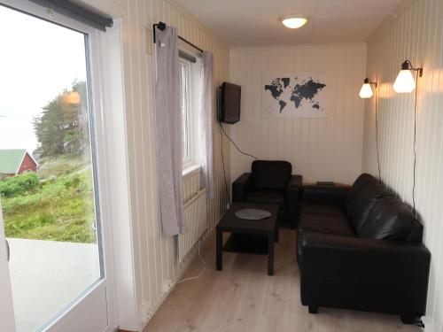 ein Wohnzimmer mit einem Ledersofa und einem Fenster in der Unterkunft Holiday Home Sognesjön - FJS128 by Interhome in Bø
