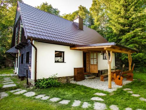 a small white cottage with a gambrel roof at Holiday Home Dolní Jílovice by Interhome in Vyšší Brod