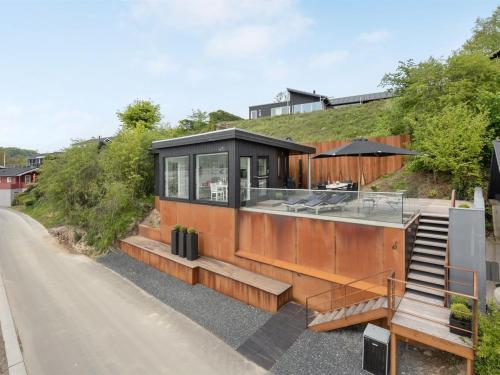 a glass house with a black roof on a hill at Holiday Home Florinda - 10m from the sea by Interhome in Haderslev