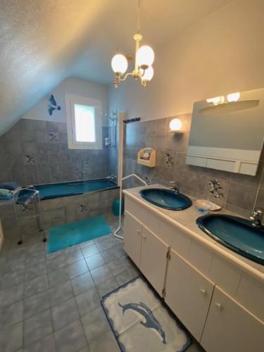 Un baño con dos lavabos y un espejo. en Chambres du Vau-Nogues, en Pleudihen-sur-Rance
