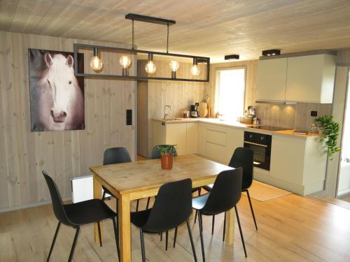 a kitchen and dining room with a wooden table and chairs at Holiday Home Bjørkstue - SOW149 by Interhome in Fossdal