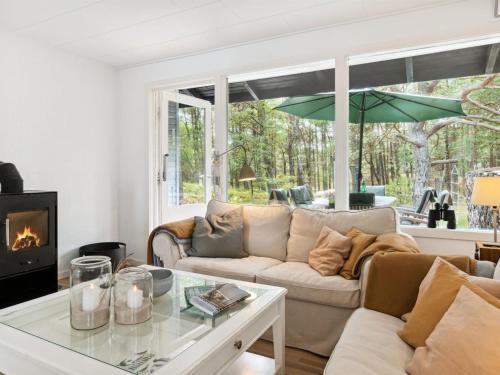 ein Wohnzimmer mit einem Sofa und einem Kamin in der Unterkunft Holiday Home Alita - 300m from the sea in Bornholm by Interhome in Vester Sømarken