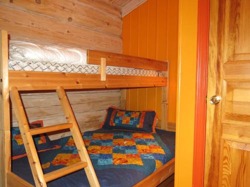 a bedroom with two bunk beds and a ladder at Chalet Kakebu by Interhome in Gjerstad