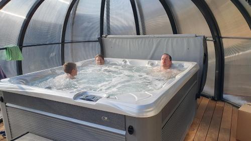 two people in a jacuzzi in a hot tub at Chalet Le Chant des Etoiles in Mende