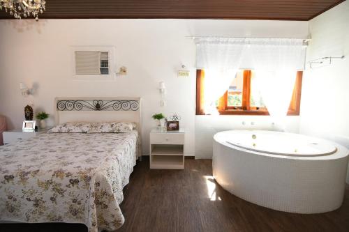 um quarto com uma cama e uma banheira em Sitio Agua Doce em Santa Branca