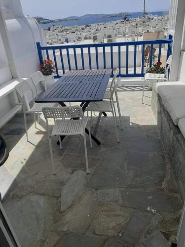 a table and chairs on a balcony with a view of the ocean at Room to rent in Mýkonos City