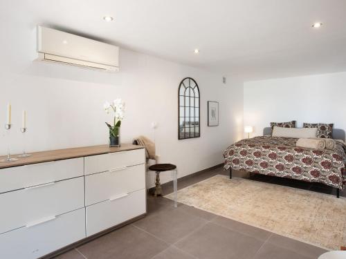 a white bedroom with a bed and a dresser at Apartment Limoneros by Interhome in Nerja