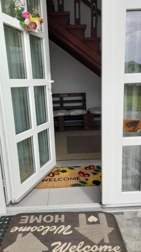 una puerta abierta con una alfombra de bienvenida en el suelo en Casa ABP, en Vatra Dornei