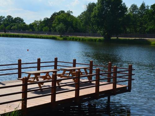 two picnic tables on a wooden dock in a lake at Holiday Home Kemp Stříbrný rybník-9 by Interhome in Hradec Králové