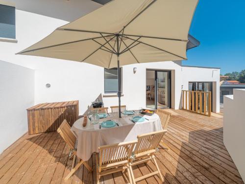 - une salle à manger avec une table et un parasol dans l'établissement Holiday Home Palot 45 by Interhome, à Mimizan