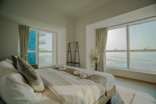 a bedroom with a large bed with large windows at Elite Residence 2BR Luxurious Palm View in Dubai Marina in Dubai