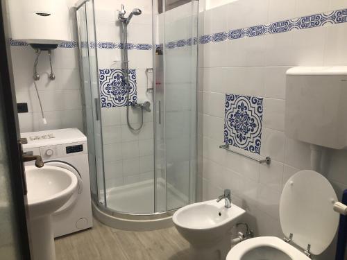 La salle de bains est pourvue d'une douche, de toilettes et d'un lavabo. dans l'établissement Villa Nogarola - apartment with private pool and garden, à Costermano