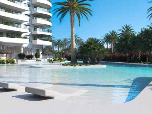 ein Swimmingpool vor einem Gebäude mit Palmen in der Unterkunft Apartment Gran Canet by Interhome in Canet d'en Berenguer