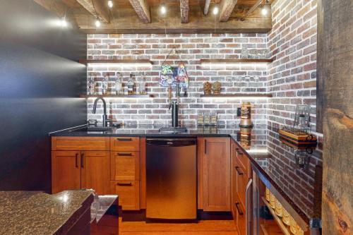 a kitchen with wooden cabinets and a brick wall at Riverside Retreat in Brockville