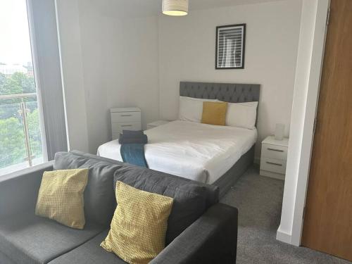 a small bedroom with a bed and a couch at Fab, Spacious Studio+Balcony MCR in Manchester