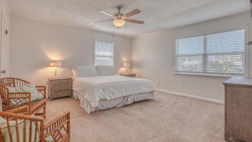 a bedroom with a bed and a ceiling fan at The Back Porch - Is a relaxing 4 bedroom 3 bathroom House on Holiday Isle in Destin